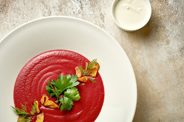 Cream soup of beet with smoked garlic in a bowl. Close-up. Selective focus. Noise added in...
