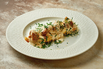 Baked potatoes with cheese sauce in a plate. Close-up. Selective focus. Noise added in...