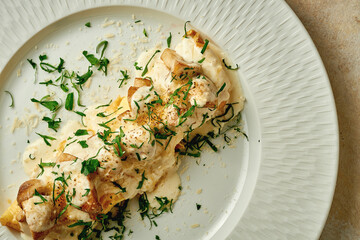 Baked potatoes with cheese sauce in a plate. Close-up. Selective focus. Noise added in...