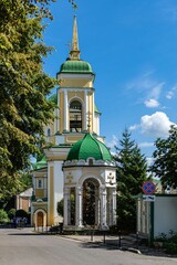 Orthodox church of Voronezh diocese. Green domes with golden Orthodox crosses against blue sky. Resurrection Church in city of Voronezh. Parishioners near entrance. Voronezh, Russia - July 30, 2022