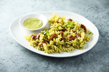 Pasta with pesto sauce and sun dried tomatoes