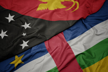 waving colorful flag of central african republic and national flag of Papua New Guinea .