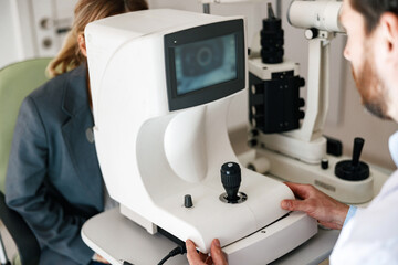 Close up of male oculist checking vision for patient with ophthalmic equipment