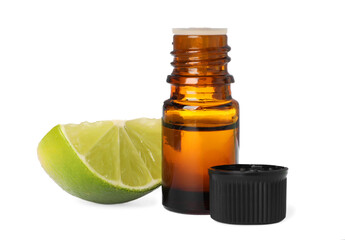 Bottle of citrus essential oil and cut fresh lime isolated on white