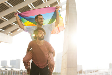  Gay couple embracing and showing their love with rainbow flag. LGBT community.