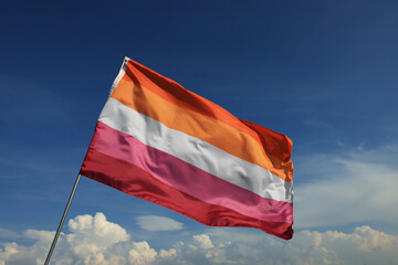 Bright lesbian flag fluttering against blue sky