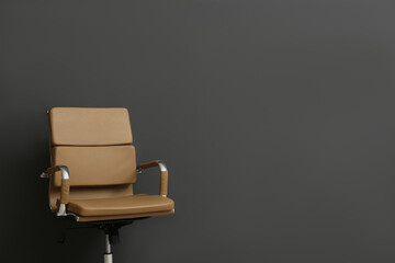 Comfortable office chair on black background. Space for text