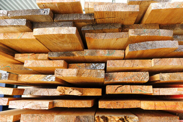 Construction lumber. Dry boards are stacked. A close-up of wood in the end. The background for the woodworking industry and sawmills.