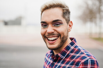 Gay man with makeup on having fun outdoor - Focus on face
