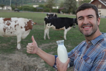 Farmer giving a thumbs up while holding fresh milk with cows in the background