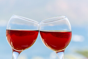 Pair of red wine glasses on landscape background