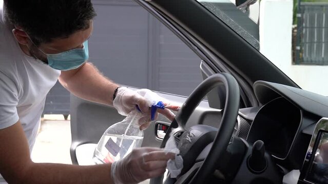 Man cleans vehicule with surgical mask