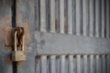 Old padlock locked the strong iron door with selective focus and copy space.