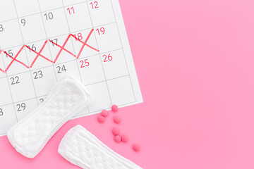 Calendar with red marks and white pad. Menstruation period concept