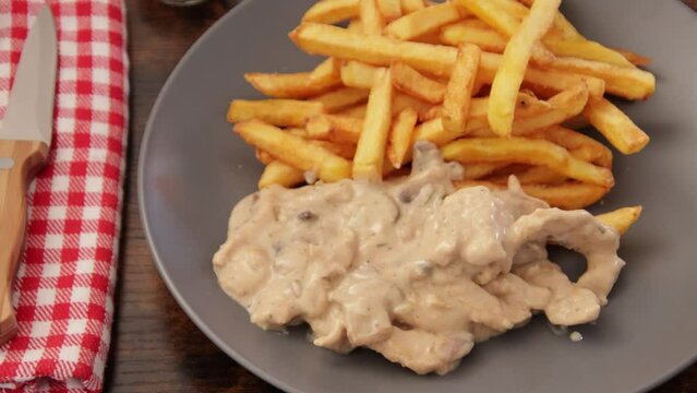 poulet en sauce et frites en gros plan dans une assiette