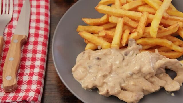 poulet en sauce et frites en gros plan dans une assiette