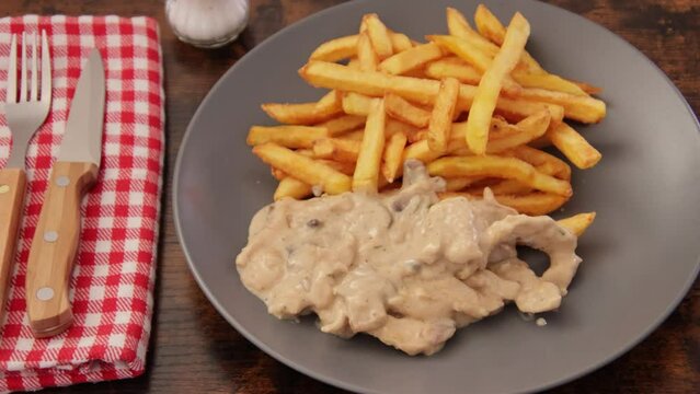 poulet en sauce et frites en gros plan dans une assiette