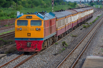 Naklejka premium Passenger train by diesel locomotive on the railway in Thailand.