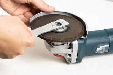 The worker spins the cleaning disk in the grinder with a special key before starting work.