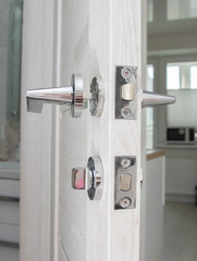 Naklejka premium Broken doorknob in interior door. Poor quality door hardware, close-up