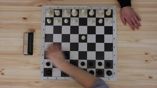 Two men plays in speed chess on wooden table. Rapid chess competition top shot close up