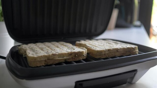 Grill with sandwiches making croque