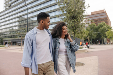 African young best friends enjoy spending time outdoors. Guy and girl wear casual clothes in spring. Rest time concept