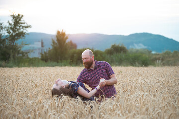 Naklejka na ściany i meble Loving couple in a wheat field.