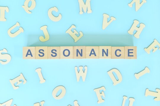 Assonance figure of speech concept in English grammar class lesson. Wooden blocks typography flat lay in blue background.
