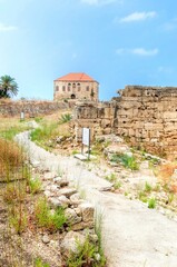 Fototapeta premium An abandoned traditional Lebanese house in Byblos, Lebanon. View of the colonial architecture with terracotta tile roof and limestone facade. 