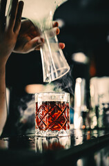 man hand bartender making cocktail in bar with smoke