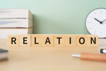 関係のイメージ｜「RELATION」と書かれたブロックが置かれたデスク
