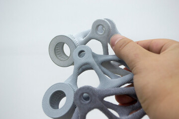 Person holding plastic model printed on powder 3d printer from biocompatible polyamide powder....