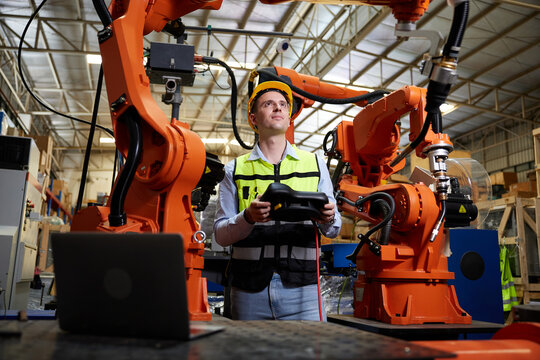 factory worker or engineer operating remote switch controller to control robot machine in the factory - Powered by Adobe