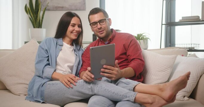 Married couple talks with friends on videocall via tablet