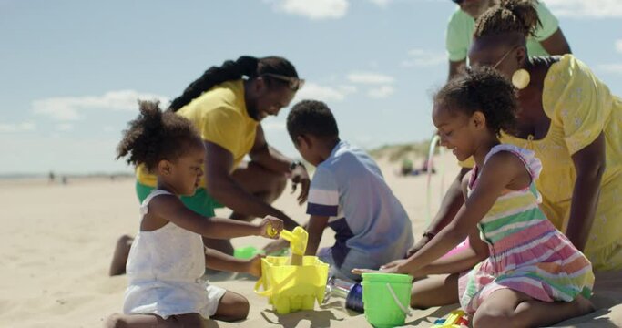 WS Family with children (2-3, 6-7, 8-9) playing on beach