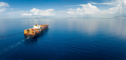 Panoramic aerial view of a industrial cargo container ship traveling over calm, open sea with copy space - obrazy, fototapety, plakaty
