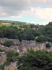 Fototapeta na wymiar scenic view of rows of typical tall stone houses between hillside trees in hebden bridge west yorkshire
