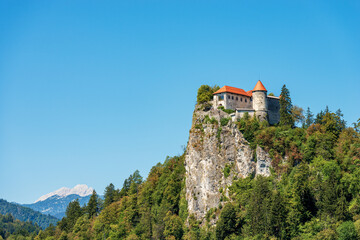 Fototapeta na wymiar Medieval Bled Castle (Blejski grad), XI century, coast of the Lake Bled (Blejsko jezero). Bled town, Gorenjska, Triglav National Park, Slovenia, Europe. On background, the peak of Triglav or Tricorno.
