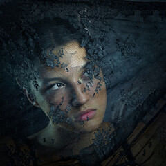 Beautiful girl behind of transparent veil