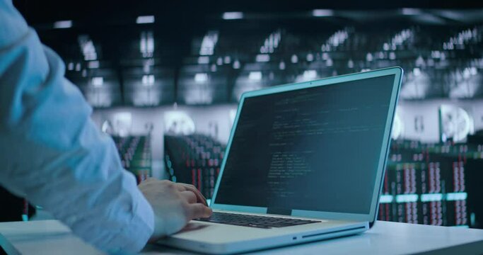 Caucasian male, IT technician using laptop, doing maintenance and diagnostics in the Server Room.