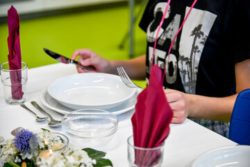 A girl in a restaurant sits at a table with empty plates and orders food.