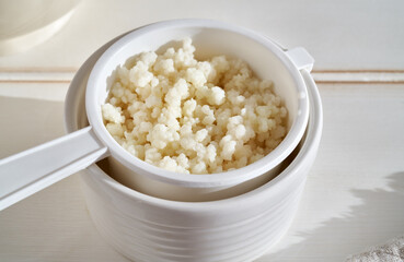 Fresh kefir grains in a white strainer - preparation of a fermented drink