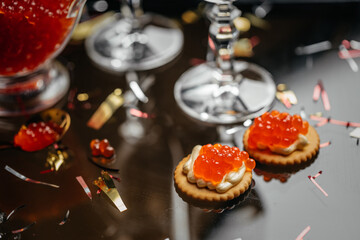 Delicious snacks with cream cheese and red caviar with glass of champagne, Festive drink. Valentins or Christmas concept