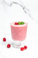 Yogurt smoothie with raspberries in glass on white marble table. weight loss concept. vertical image. place for text