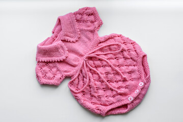 Beautiful baby knitted clothes and a toy for a newborn baby