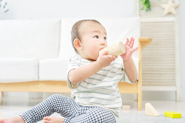 Fototapeta premium リビングで一人で積み木で遊ぶ赤ちゃん