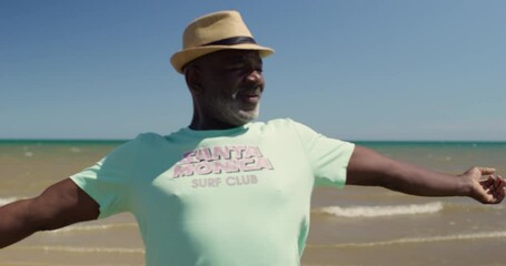 MS Senior man standing on beach with spread arms