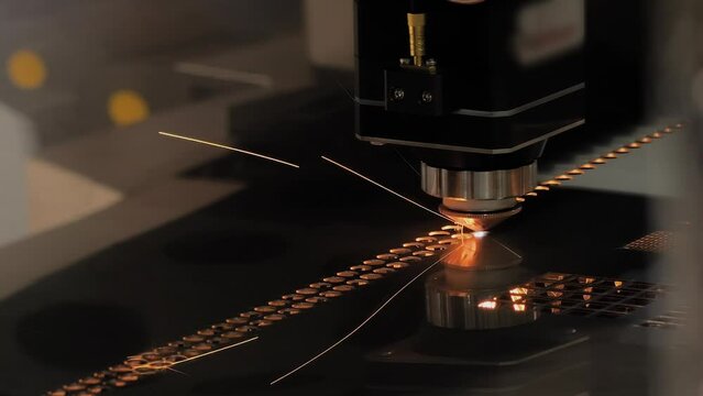 Close up: automatic cnc laser cutting machine working with sheet metal with many sparks at factory, plant - slow motion. Metalworking, industrial, manufacturing, technology and equipment concept