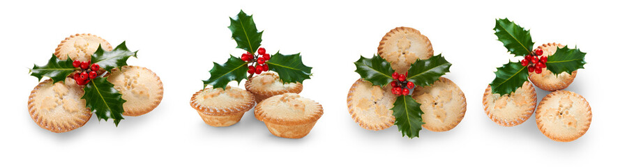 A collection of Christmas mince pies with holly isolated against a flat background.